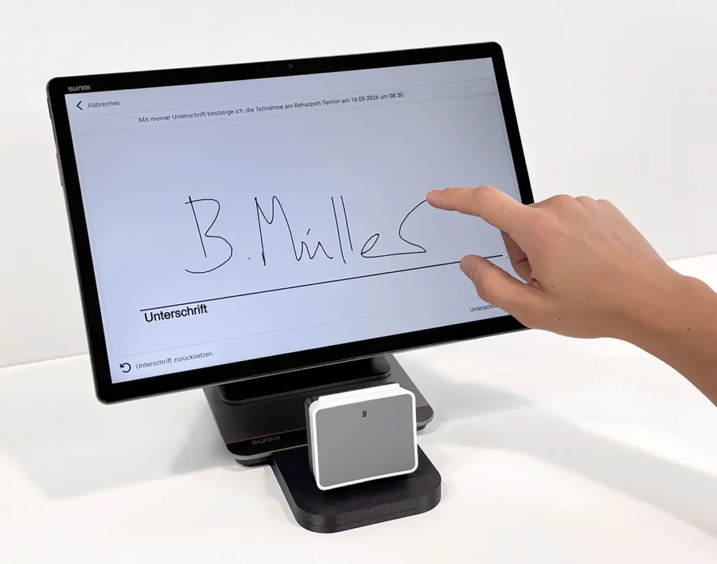 Eine Hand unterschreibt auf dem Touchscreen eines Selbstbedienungsterminals.